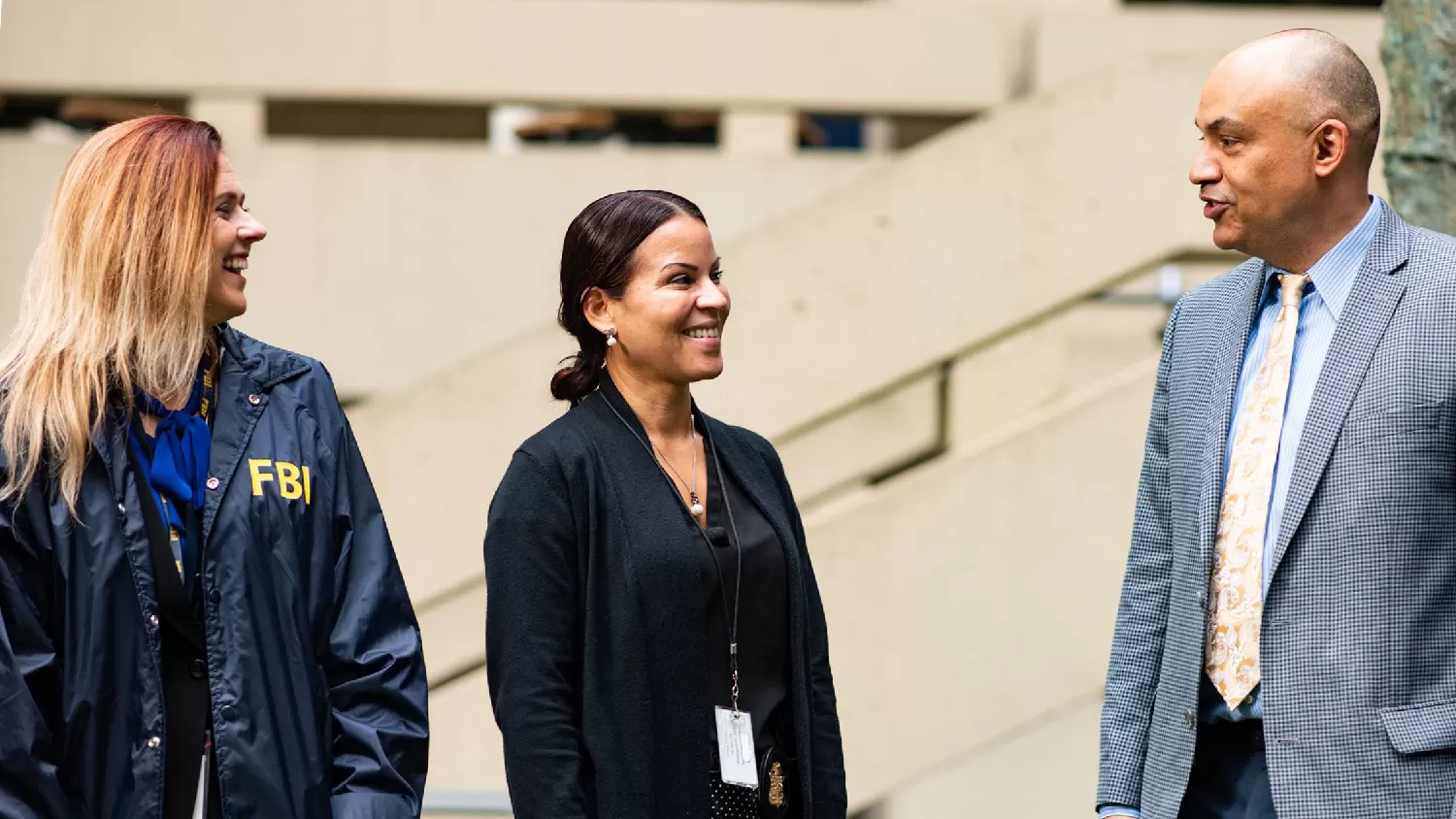 Three special agents, 2 females and 1 male, standing outside and talking to one another