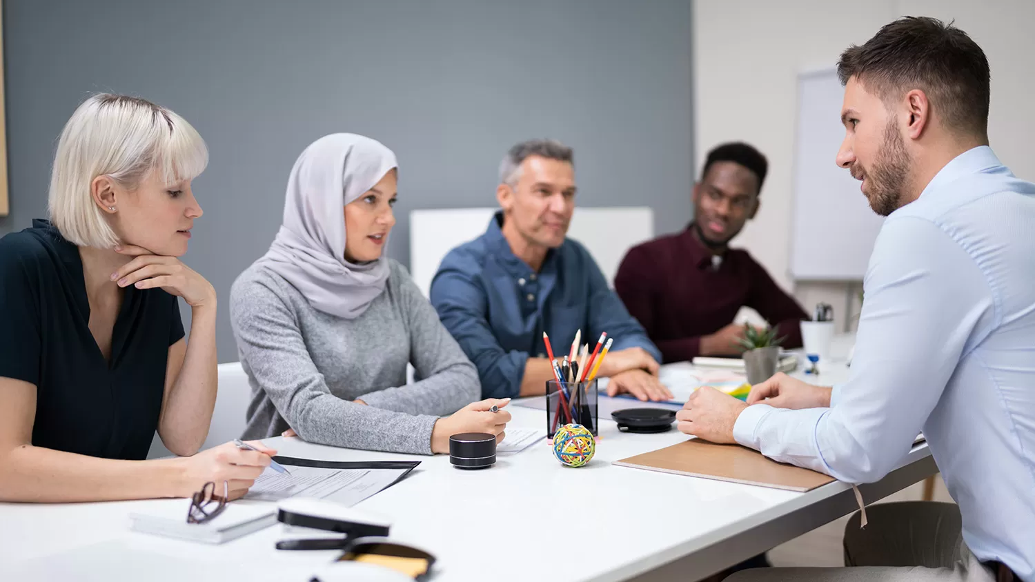 Small group of males and females sitting around a table having a conversation