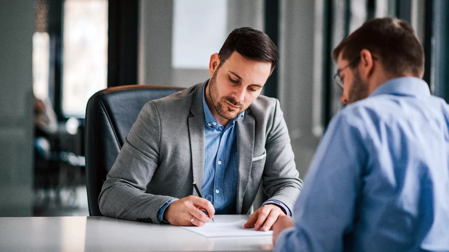 Two men filling out paperwork