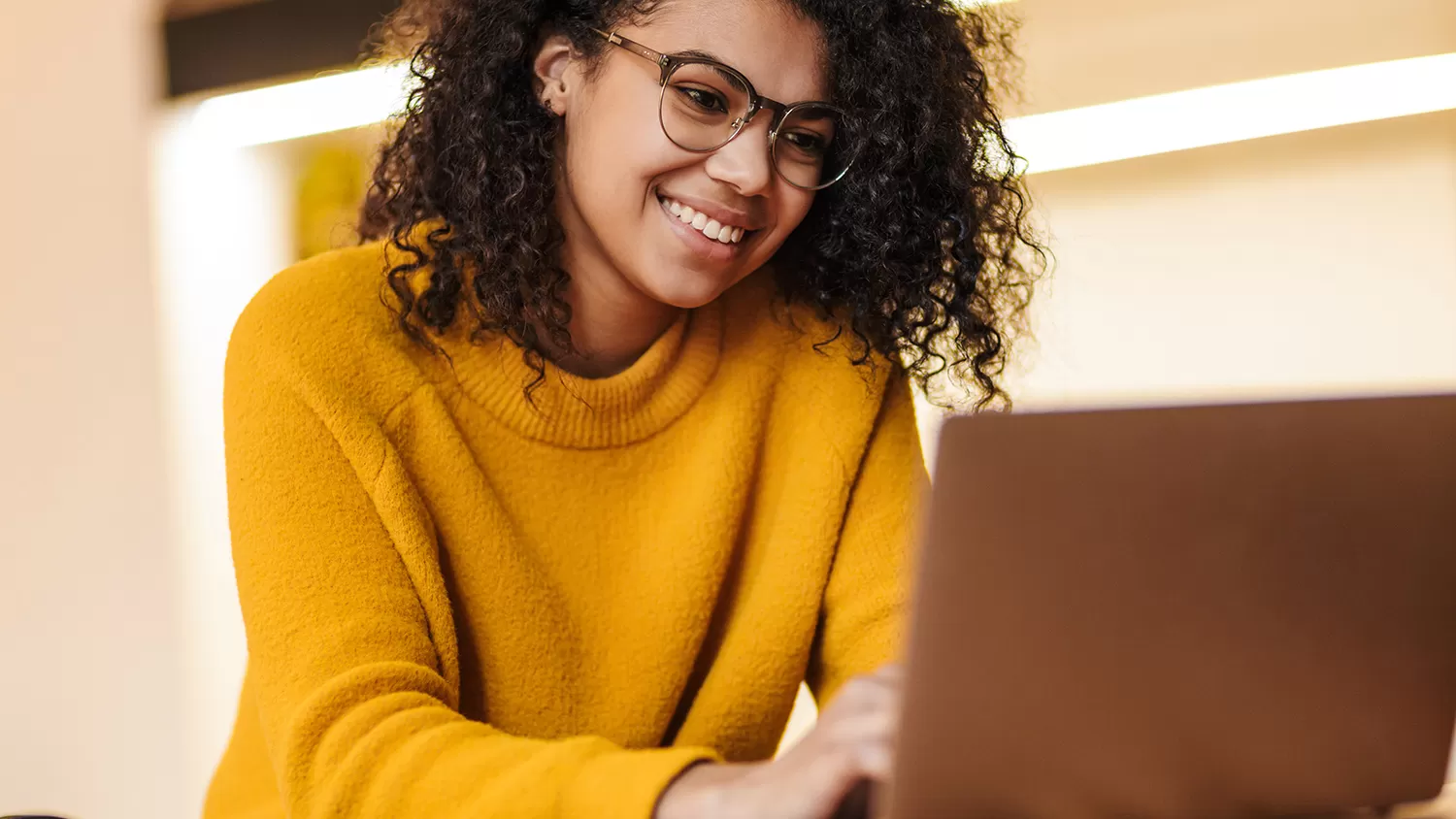 Female smiling while looking and typing on a computer 