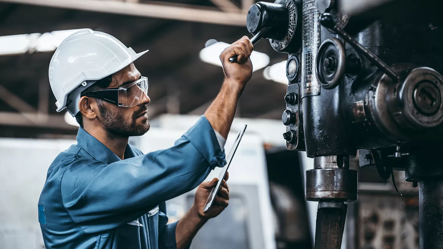 A man in a hardhat working on a machine