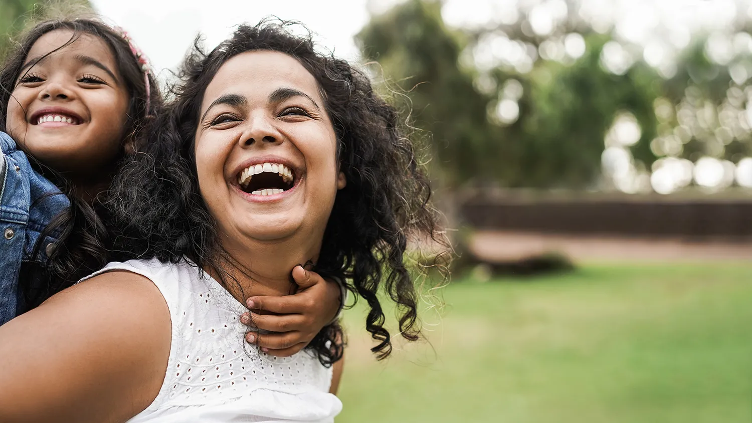 Mother and daughter smiling in park