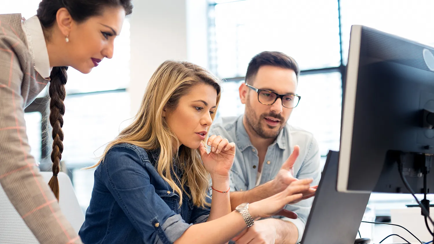 People talking and looking at a computer