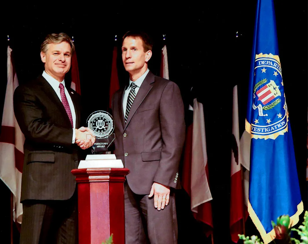 Kyle accepts a Director's Award from FBI Director Wray