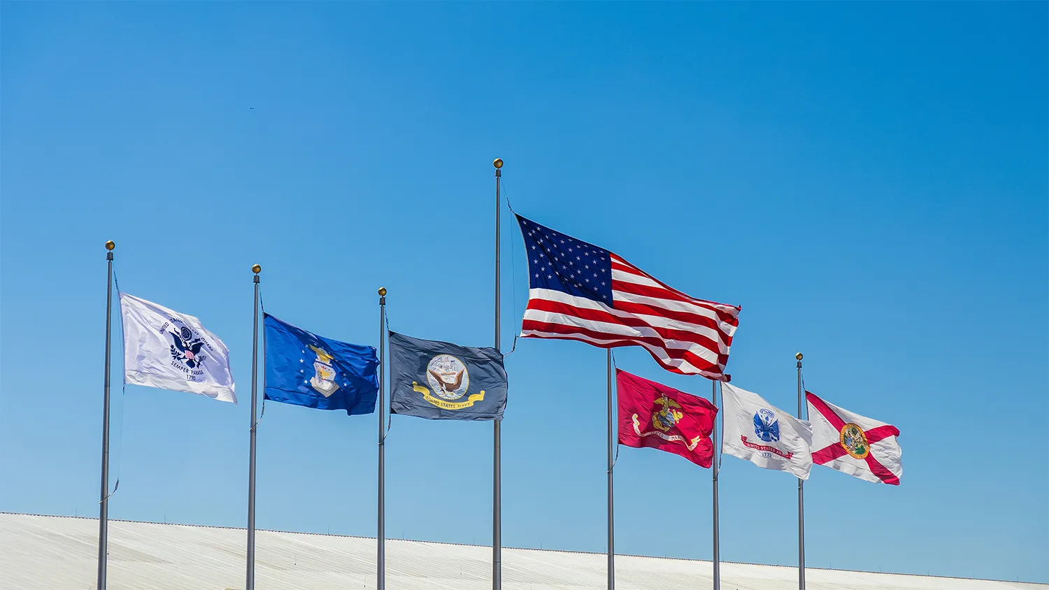 Flags representing different military branches fly at full staff.